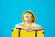 © Sunny studio - Portrait of happy child with yellow suitcase. Summer vacation concept