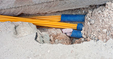 Worker Inserts Fiber Optic Cables Buried In A Micro Trench
