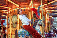 Woman Riding On A Traditional Vintage Carousel In A City Park