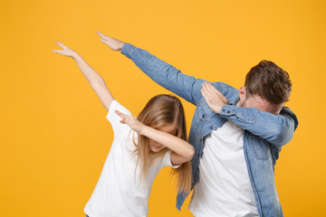 Cheerful man in casual clothes have fun with cute child baby girl. Father little kid daughter isolated on yellow background. Love family day parenthood childhood concept. Showing DAB dance gesture.