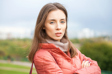 Wall Mural - Close up portrait of a young beautiful brunette girl in coral coat