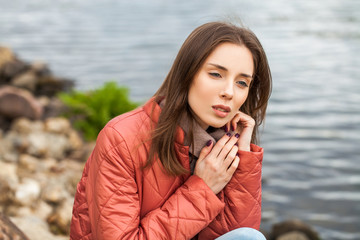 Wall Mural - Close up portrait of a young beautiful brunette girl in coral coat