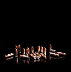 Poster - Shiny cartridges for the gun on a dark background. Ammunition for the gun. Pistol cartridges. Bullets and shell bullets on black.