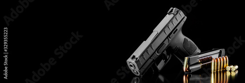 Fotomural Black modern gun and ammunition for it on adark background