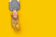 Excited crazy little blonde girl hanging happy upside down over isolated yellow studio background. Emotion, expression. Copy space for text.