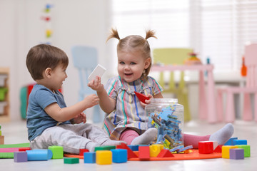 Wall Mural - Cute little children playing together on floor at home