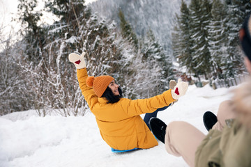 Wall Mural - Couple having fun and sledding on snow. Winter vacation