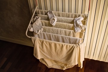 Little clotheshorse hanging on the radiator with towels, socks and a t-shirt (Pesaro, Italy, Europe)