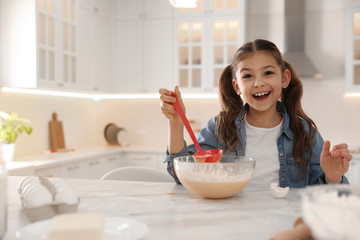 Poster - Cute little girl cooking dough at table in kitchen