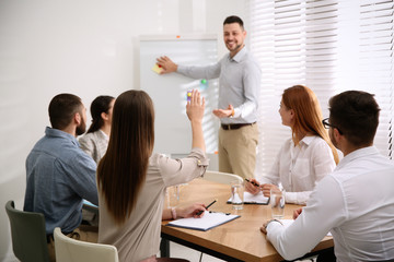 Wall Mural - Young woman raising hand to ask question at business training in conference room