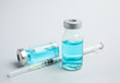 © New Africa - Vials and syringe on light background. Vaccination and immunization