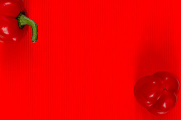 Sliced red sweet pepper (bell pepper, bulgarian pepper) is on a red relief background. Copy space.