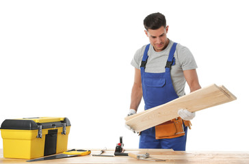 Poster - Handsome carpenter working with timber at wooden table on white background