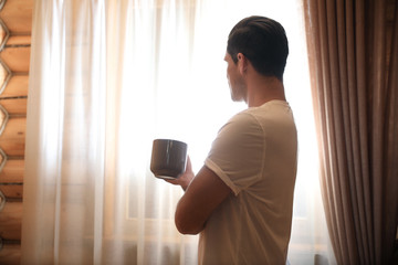 Poster - Man with drink near window indoors. Lazy morning