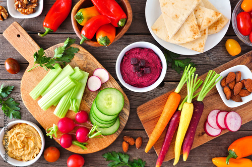 Fotografía Table scene with a variety of fresh vegetables and hummus dips