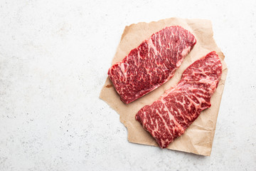 Wall Mural - Raw Steak on paper on white background, top view