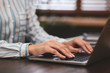 © New Africa - Woman working on modern laptop at table, closeup