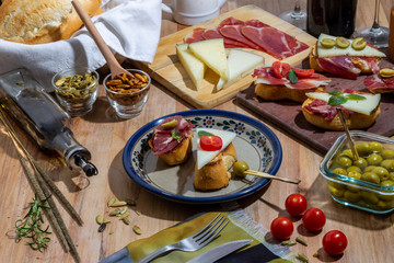 Exquisite still life of wine, cheese and meat products, olives, seeds and wine