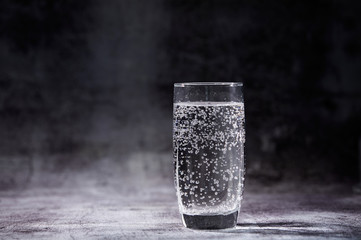 Glass of sparkling water on the grey background