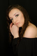 © emiphoto111 - portrait of beautiful young brunette girl in studio with professional make up on black background, hands near face, bare shoulder, sensual expression, vertical image