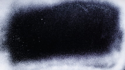 Real frost on a window. Frostwork pattern ice crystals on black background. Dark surface with abstract ice structure makes to overlay or add a frost effect.