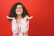 © denis_vermenko - Happy cheerful young woman with curly hair rejoicing at positive news or birthday gift, Student girl relaxing after college isolated over red background.