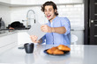 © F8  \ Suport Ukraine - Young pretty man play games on tablet while having breakfast in the kitchen