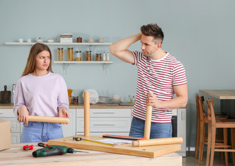 Wall Mural - Emotional couple assembling furniture at home