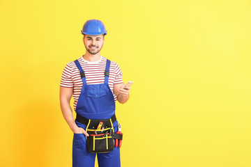 Sticker - Handsome male worker with mobile phone on color background