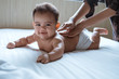 © Odua Images - prone baby happy is smile his back by his mother while lying in the bedroom