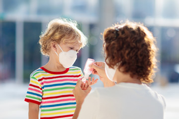 Wall Mural - Mother and child with face mask and hand sanitizer