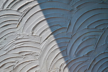  Light and shadow on textured concrete wall 
