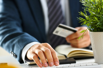 male arms hold credit card press buttons making transfer closeup. anti-fraud financial security when