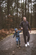 © ILIA - A little boy walks in the woods with his dad wearing walking jumpsuits