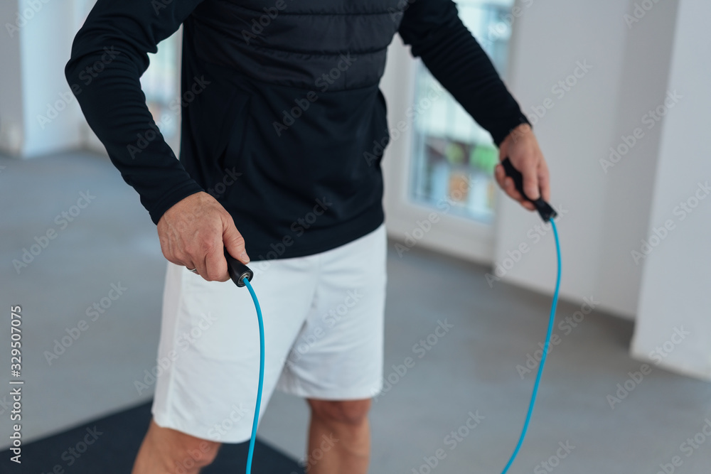 Man working out with a skipping rope in a gym - obrazy, fototapety, plakaty 