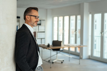 Wall Mural - Pensive smart businessman standing deep in thought