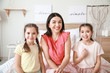 © Pixel-Shot - Woman and her little daughters video chatting at home