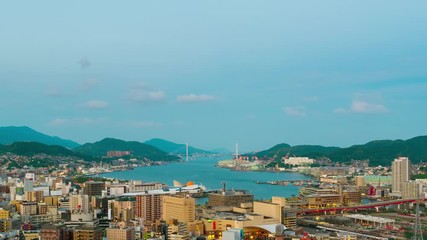 Wall Mural - Nagasaki, Japan. A sunrise timelapse made from a hill in Nagasaki, Japan, with a view over the entire center, including the bay and the hills., panning video