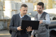 © auremar - constructor and manager working on modern tablet outside renovated factory