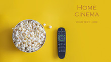 Popcorn Bowl And Remote Control On Yellow Background.  Smart Tv And Home Cinema Concept.