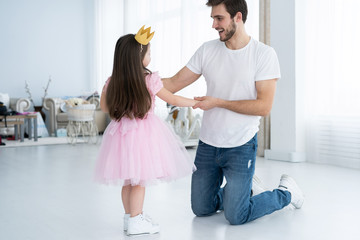 Wall Mural - I love you, dad! Handsome young man is dancing at home with his little girl. Happy Father's Day!