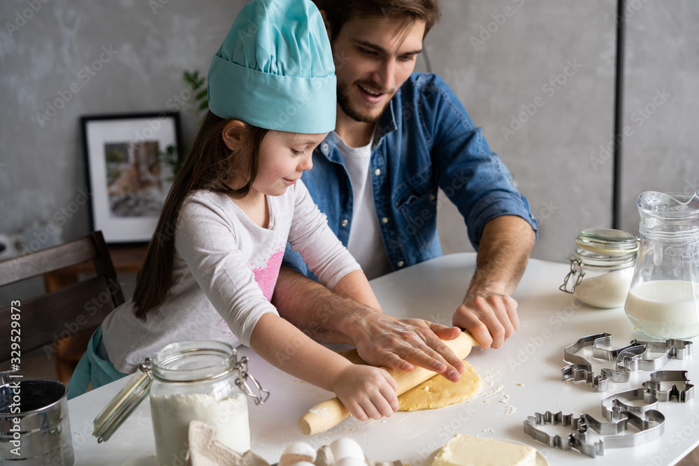 Father and little daughter baking pastries. Family having fun in kitchen and getting ready for a party. - obrazy, fototapety, plakaty 