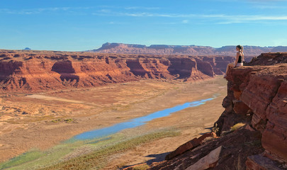 COPY SPACE: Woman sits on the edge of cliff overlooking disappearing Lake Powell