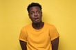 © Viktor Koldunov - Young african american black man surprised face expression. Studio shot on yellow wall.