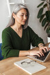 © Drobot Dean - Photo of gray-haired focused businesswoman typing on laptop