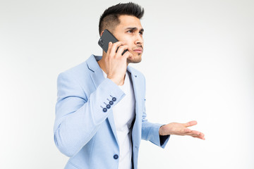 businessman in a jacket discusses important matters on the phone on a white background