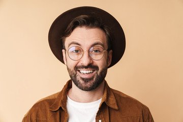 Wall Mural - Happy young unshaved man in hat isolated