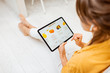 © rh2010 - Young woman shopping fresh food online using a digital tablet, while sitting on the floor at home. Concept of buying online using mobile devices