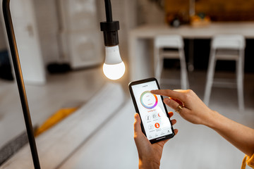 controlling light bulb temperature and intensity with a smartphone application. concept of a smart h