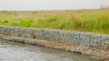 Gabion Retaining Walls To Control Erosion And Flooding On The Banks Of A Fast Flowing River